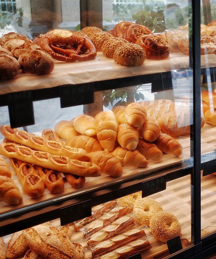 Pastries and loaves stacked on the shelves of a bakery window