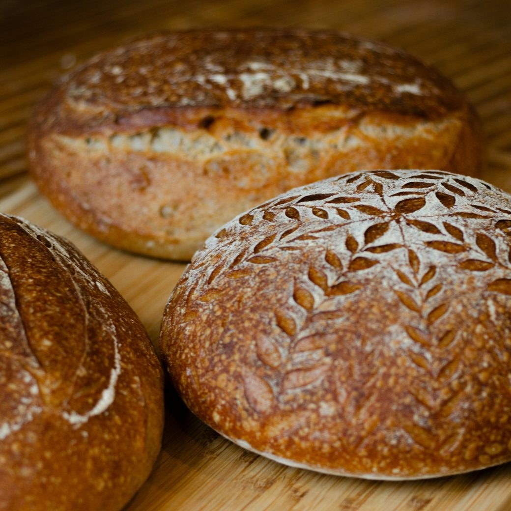 Fresh sourdough loaves cooling on a wooden board