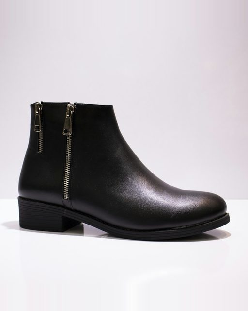 A black leather ankle boot on a white table