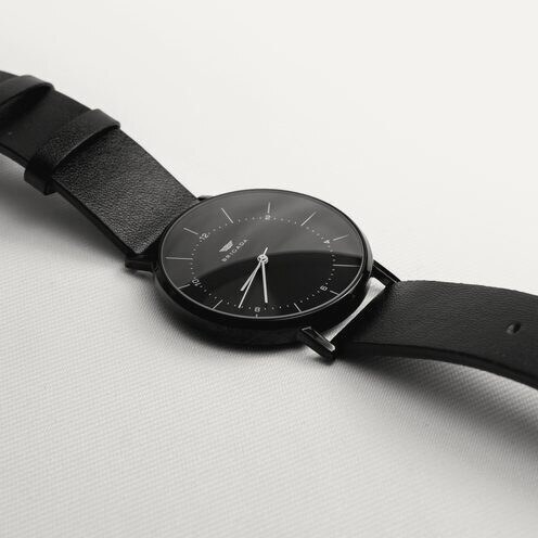 A minimalist black wristwatch on a leather strap