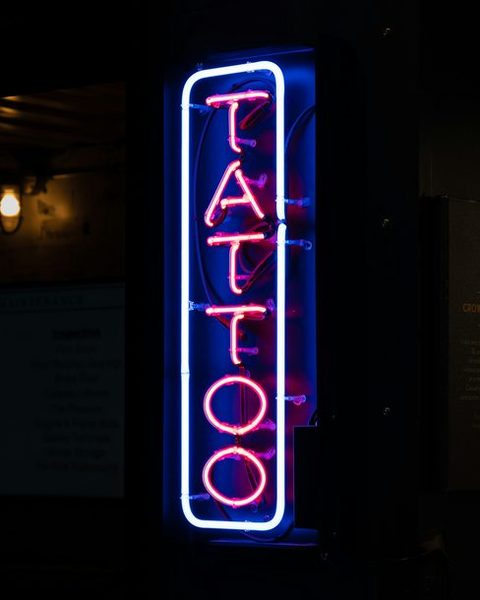 A glowing neon sign in a dark shop window