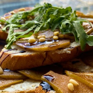 Toast topped with roasted pear slices, pine nuts and rocket