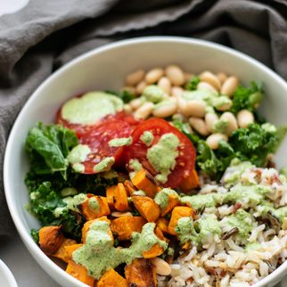 A grain bowl with roasted squash, greens and white beans