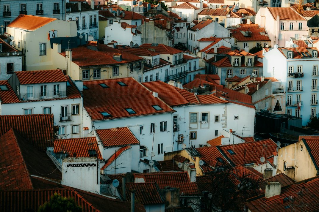 White houses and red tiled roofs climbing a hillside