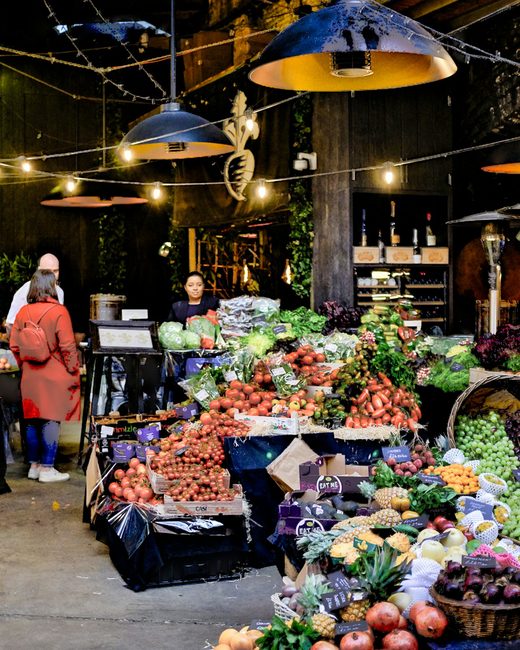 A covered food market with crates of fruit and vegetables