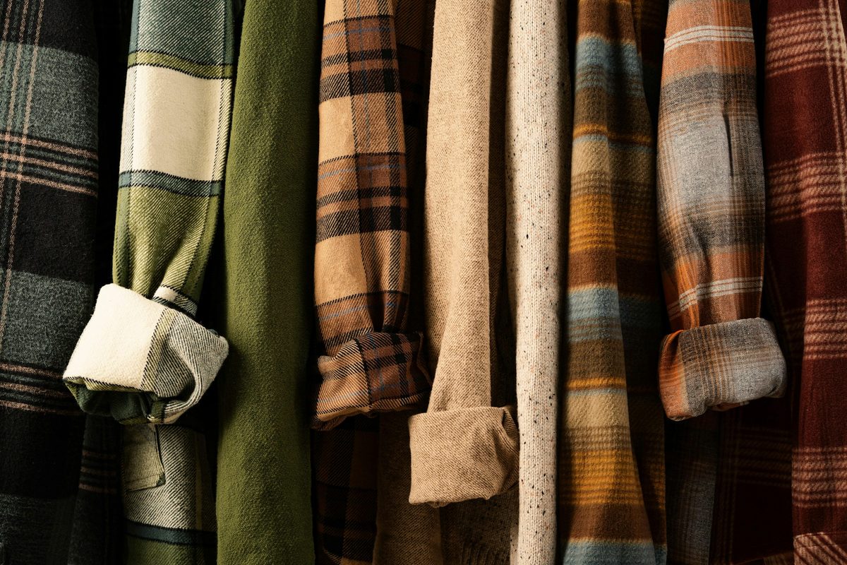 A rack of plaid flannel shirts and jackets hanging side by side
