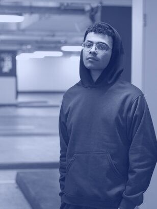 Man in a heavyweight black hoodie in a parking lot