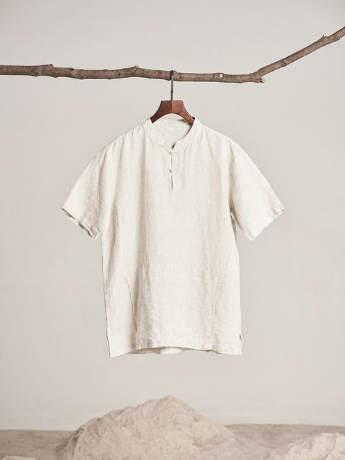 A white linen blouse hanging from a branch