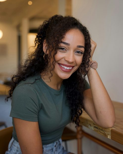 Aisha Reyes smiling at a wooden table