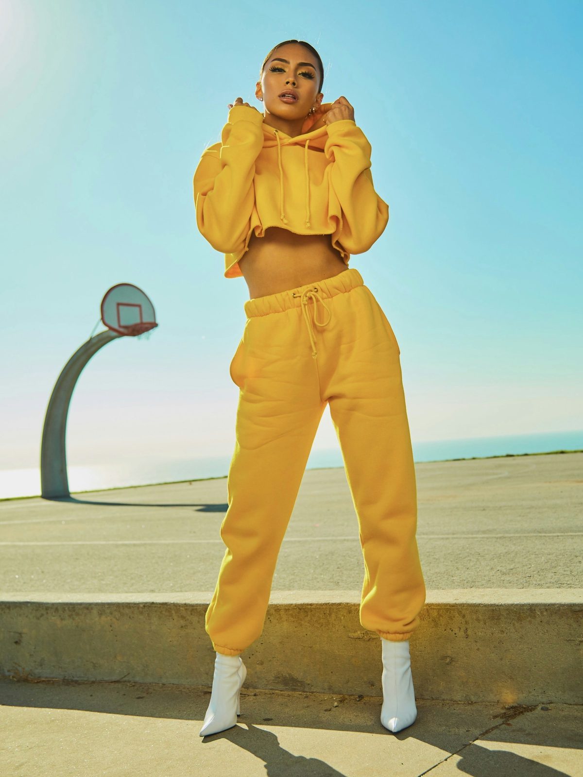 Woman in a yellow tracksuit at the side of a basketball court