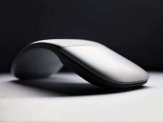 A curved wireless mouse on a plain surface