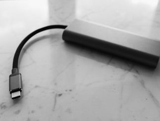 A slim power bank with a USB-C cable on marble