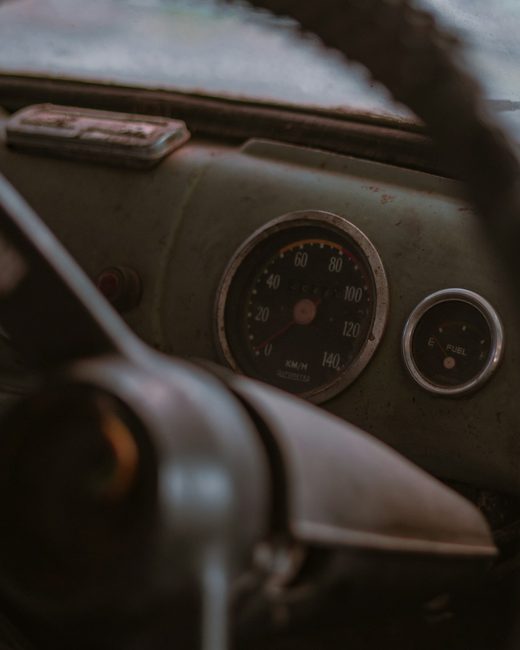 A dusty car dashboard and steering wheel before detailing