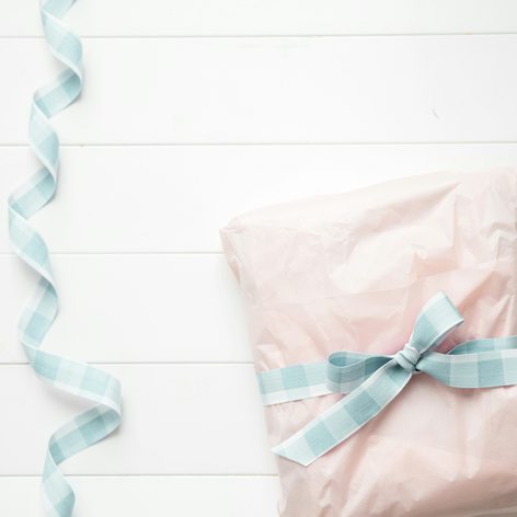 A small gift in pink paper tied with a gingham ribbon