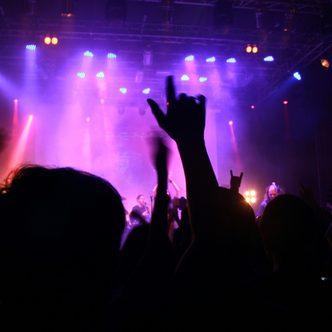 The crowd on Saturday night, hands up under purple light