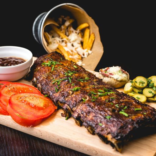 A glazed rack of baby back ribs on a wooden board