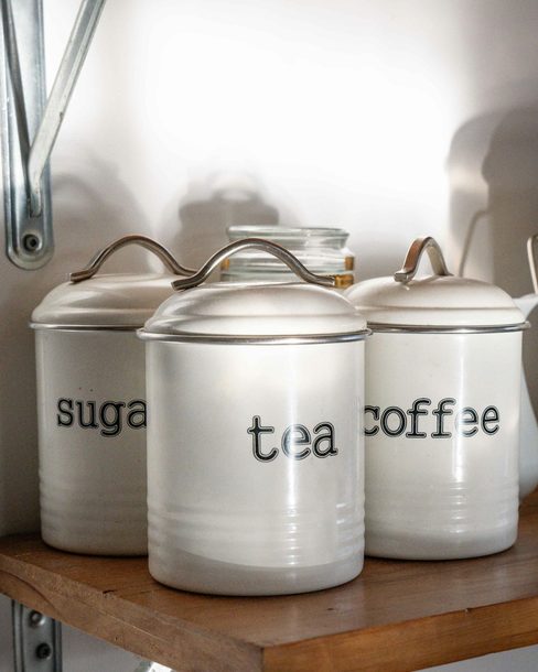White enamel canisters on a kitchen shelf