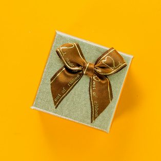 A small wrapped gift box on a bright yellow background