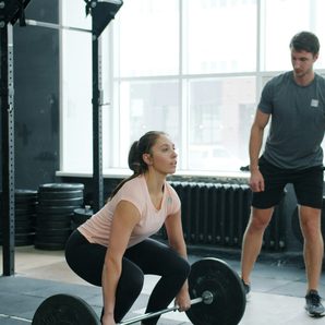 A coach spotting a beginner lift