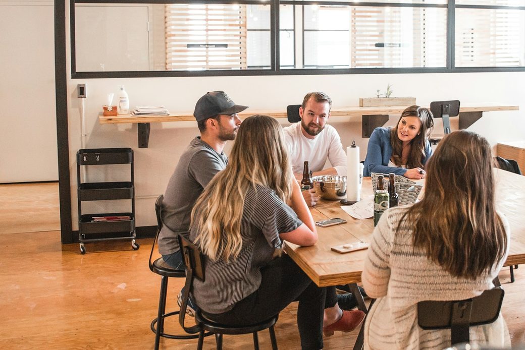 A small team talking around a shared table in a bright office