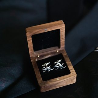 Silver cufflinks in an open wooden box