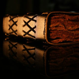 A leather-bound journal with a stitched spine lit from the side