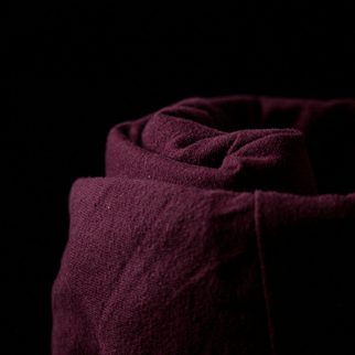 A folded burgundy cashmere scarf in low light
