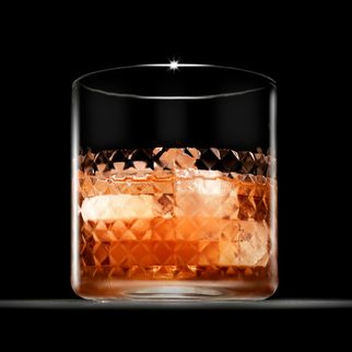 A cut crystal tumbler on a dark wooden table