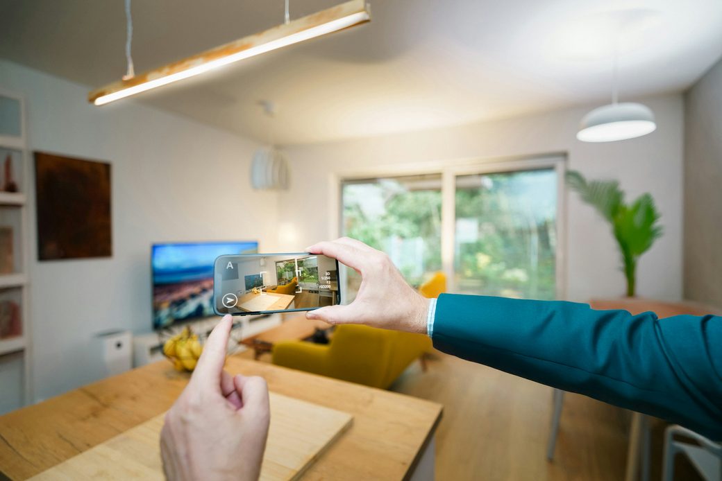 A phone photographing a bright living room for a rental listing