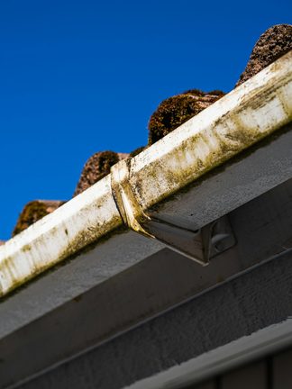 A roof gutter against a blue sky