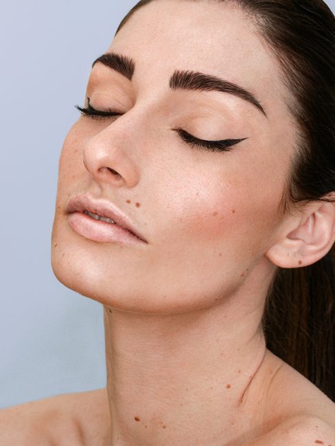 A woman with shaped brows and lifted lashes, eyes closed