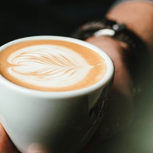 Hands holding a cup with a simple poured heart