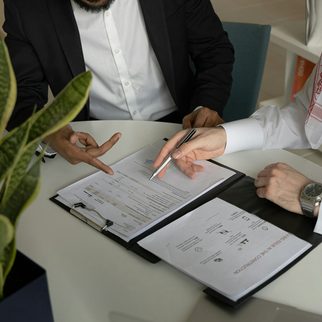 Two people reviewing and signing papers at a table