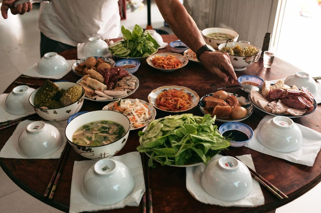 A round table set with many small shared dishes for a New Year's Eve reunion dinner