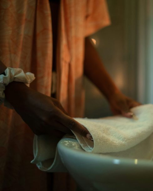 A therapist folding a towel beside a lit candle