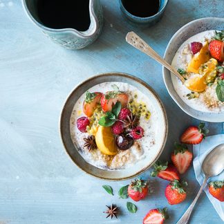 Two bowls of porridge topped with berries