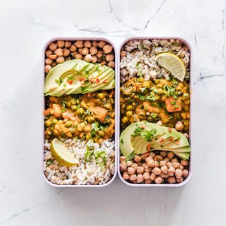 Two meal-prep boxes of chickpeas, rice and avocado