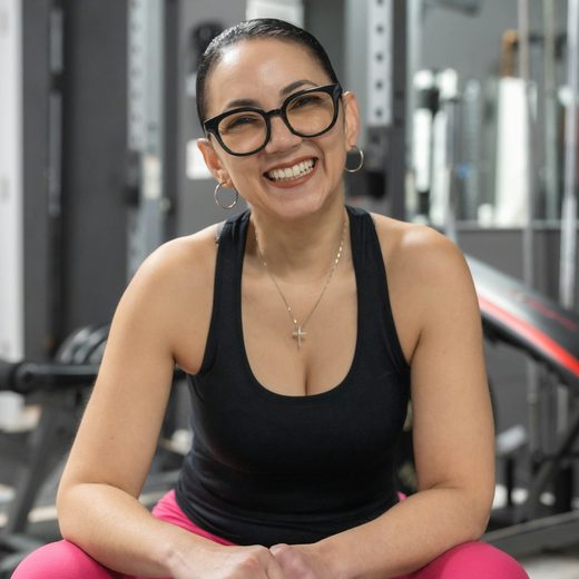 Elena, smiling on a bench in the gym