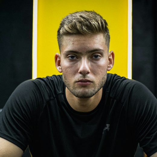 Sam, sitting in front of a yellow wall