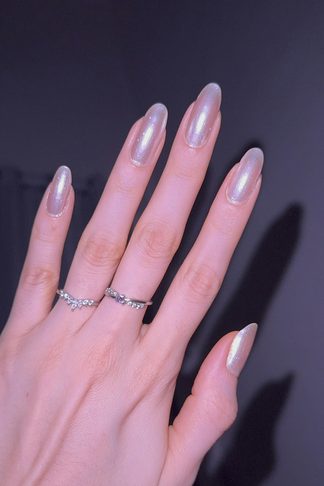 Long almond nails with a pearl chrome finish and fine rings