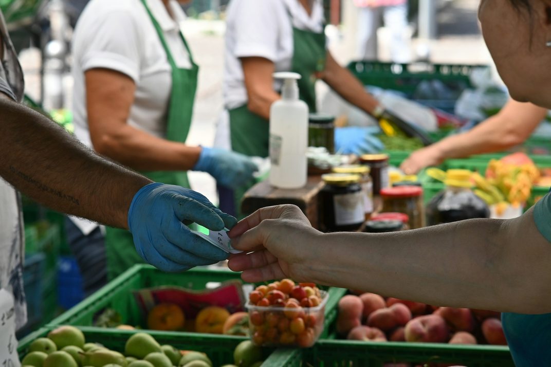Volunteers handing out fresh fruit and vegetables at a distribution table