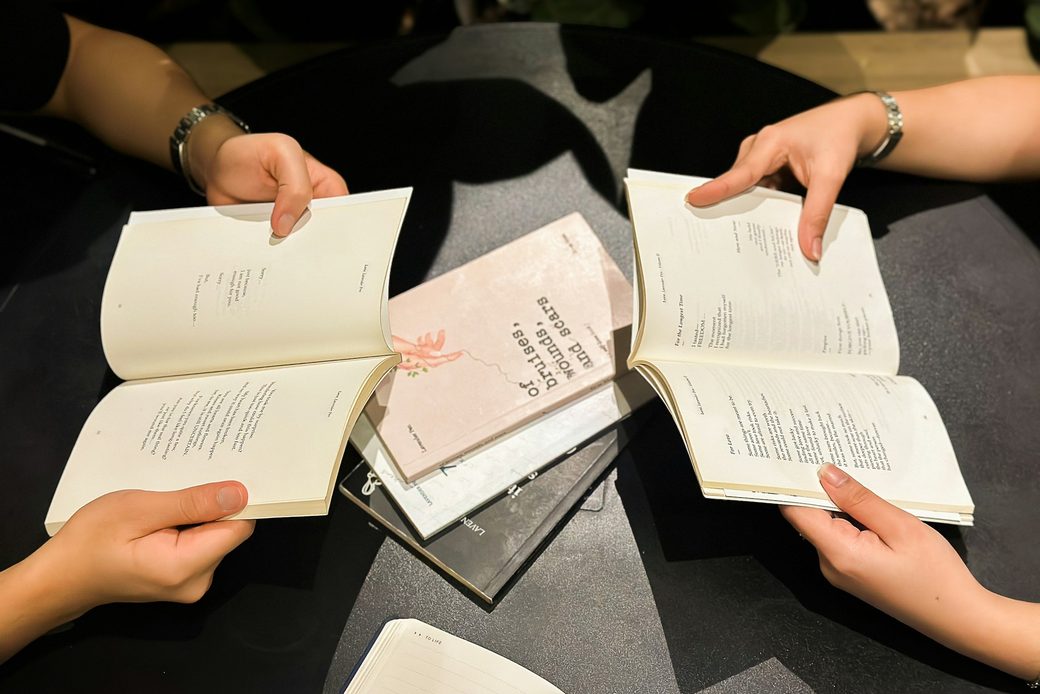 Several people holding open books around a table