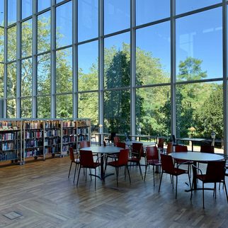 A bright library with tall windows and reading tables
