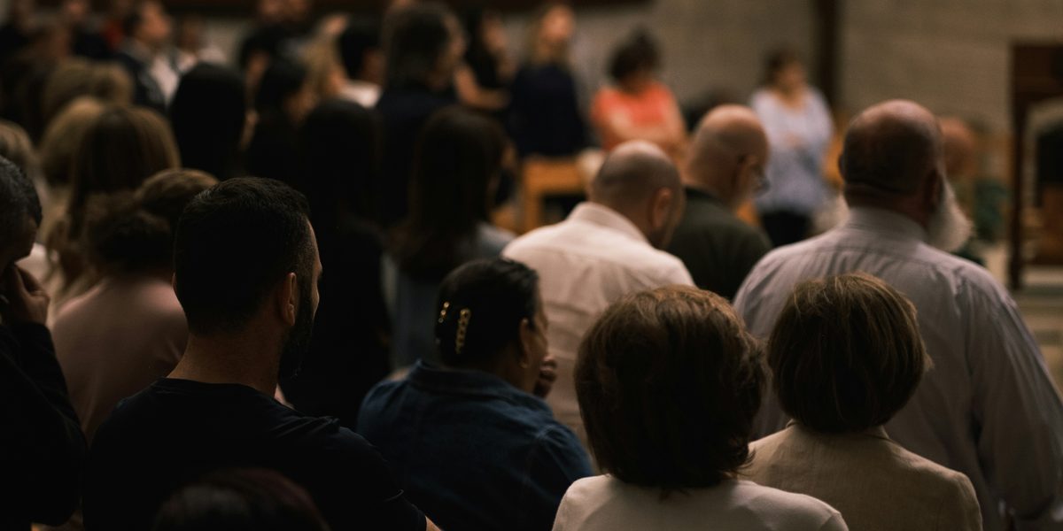 A congregation seated together, seen from behind