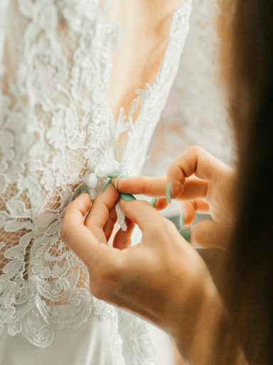 Hands fastening a dress