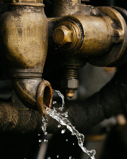 Water dripping from an old brass pipe fitting