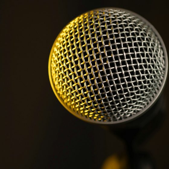 A studio microphone lit by a warm yellow light