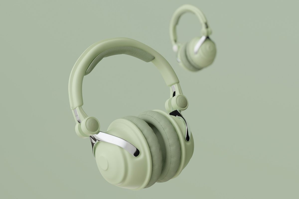 Sage green over-ear wireless headphones floating against a sage backdrop