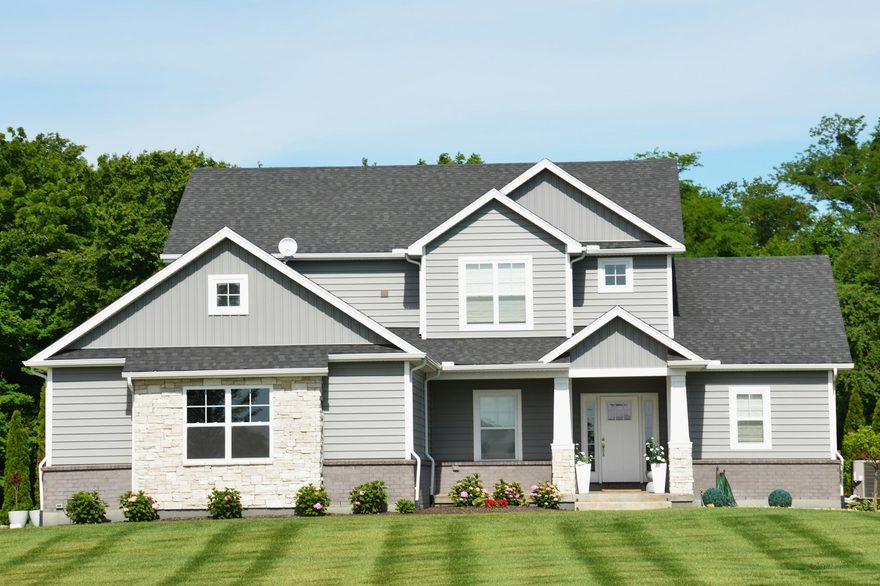 119 Elm Street, a gray two-story house with a wide green lawn