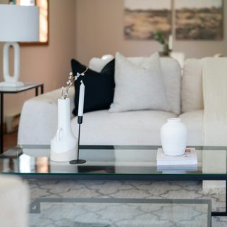 A staged living room with a white sofa and a glass coffee table
